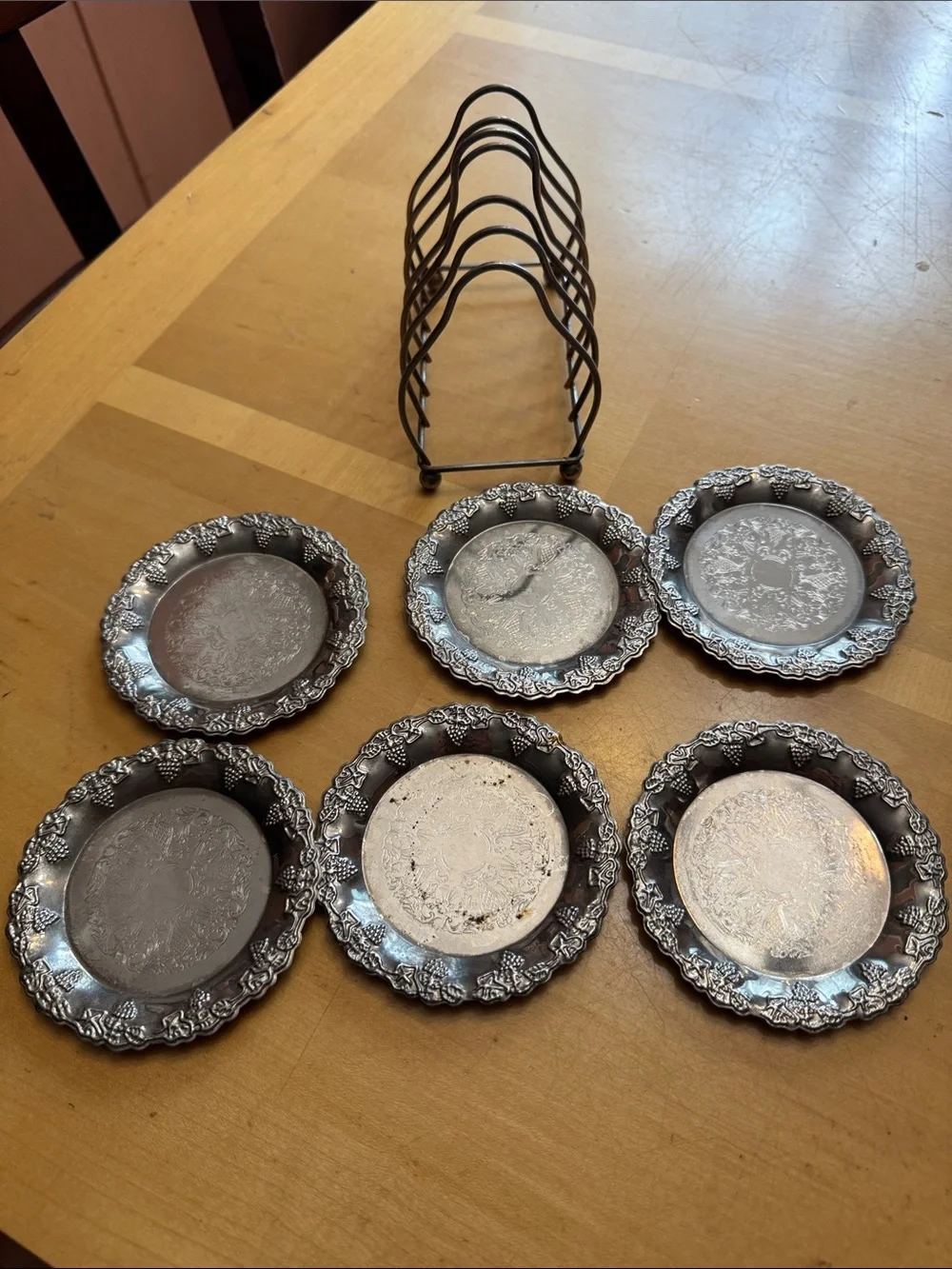 six vintage silver-plated drink coasters with ornate, embossed floral